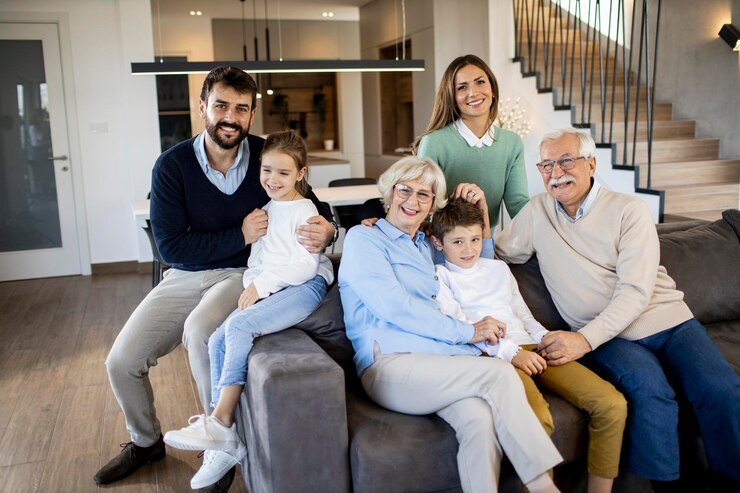 Foto famiglia multigenerazionale seduta insieme sul divano in un appartamento moderno