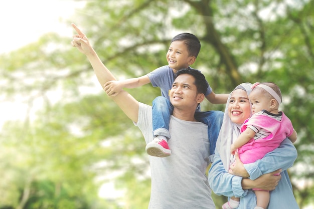 Famiglia musulmana che guarda qualcosa nel parco