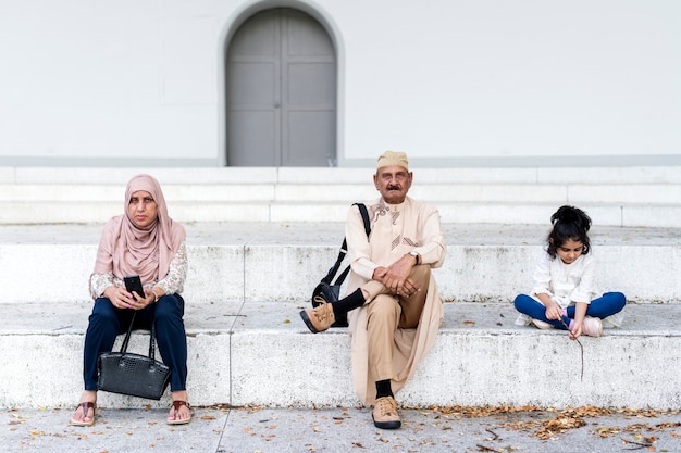 Famiglia musulmana che si siedono insieme all&#39;aperto