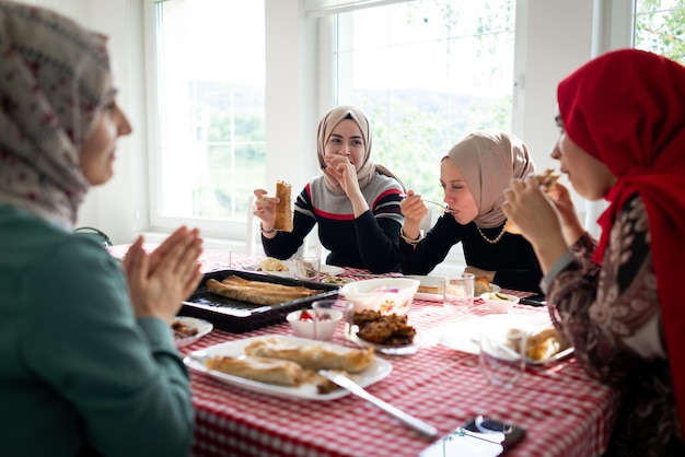 Famiglia musulmana e amici che si riuniscono a casa per cenare foto di alta qualità