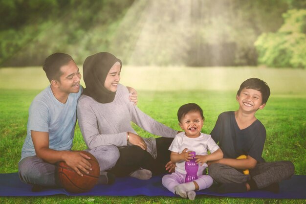 Famiglia musulmana si riposa dopo l'esercizio nel parco