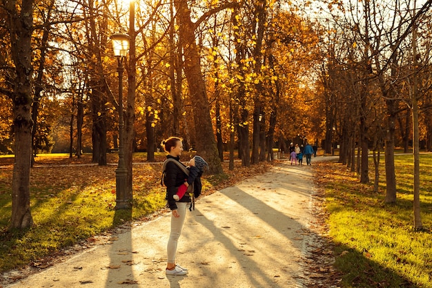 Famiglia nella natura del parco autunnale Madre e bambino felici insieme sulla natura in autunno