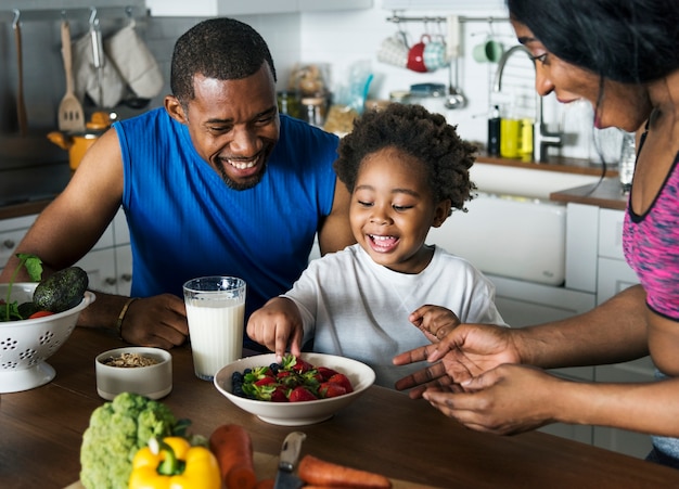 Famiglia nera che mangia insieme cibo sano