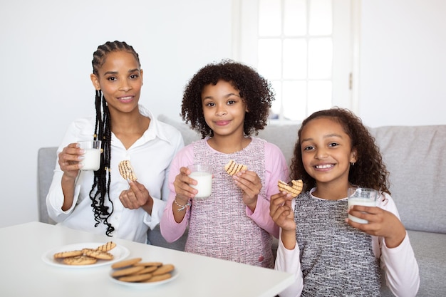 Famiglia nera che pranza insieme a casa sorridendo alla macchina fotografica