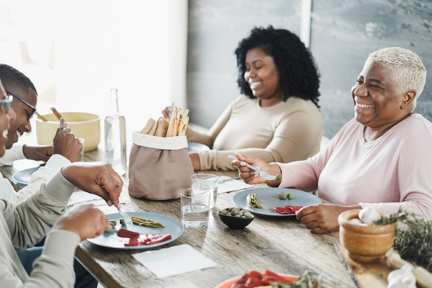 Famiglia nera felice che mangia pranzo a casa