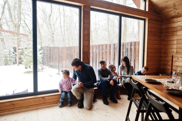 Famiglia numerosa in una moderna casa di legno che trascorre del tempo insieme con calore e amore