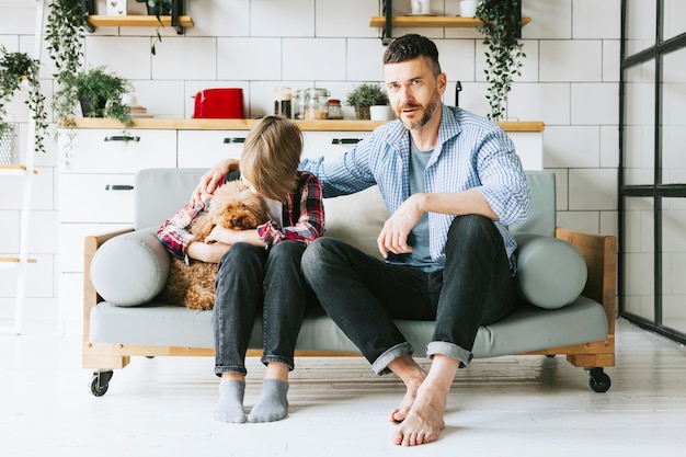 famiglia papà giovane uomo calma suo figlio adolescente ragazzo carino sul divano in un accogliente appartamento tempo di qualità con la tua famiglia adolescente sconvolto che perde nel calcio