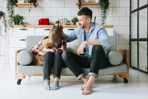 famiglia papà giovane uomo calma suo figlio adolescente ragazzo carino sul divano in un accogliente appartamento tempo di qualità con la tua famiglia adolescente sconvolto che perde nel calcio