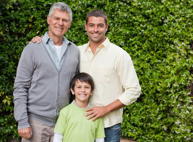 Famiglia radiosa che esamina la macchina fotografica nel giardino