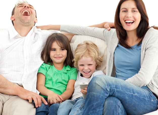 Famiglia ridendo mentre si guarda la televisione insieme