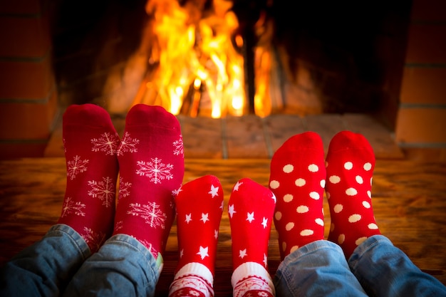 Famiglia rilassante a casa. Piedi in calzini di Natale vicino al camino. Concetto di vacanza invernale