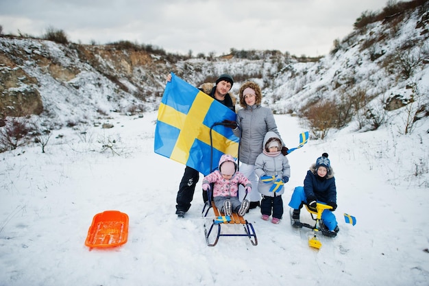 Famiglia scandinava con bandiera svedese nel paesaggio svedese invernale