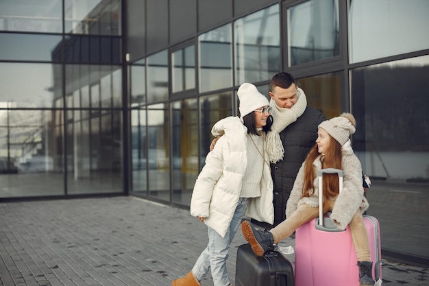 Famiglia seduta all'aperto su un bagaglio e in attesa di viaggiare