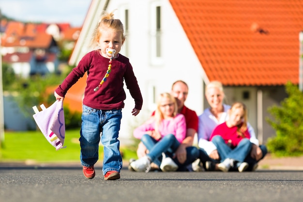 Famiglia seduto di fronte a casa