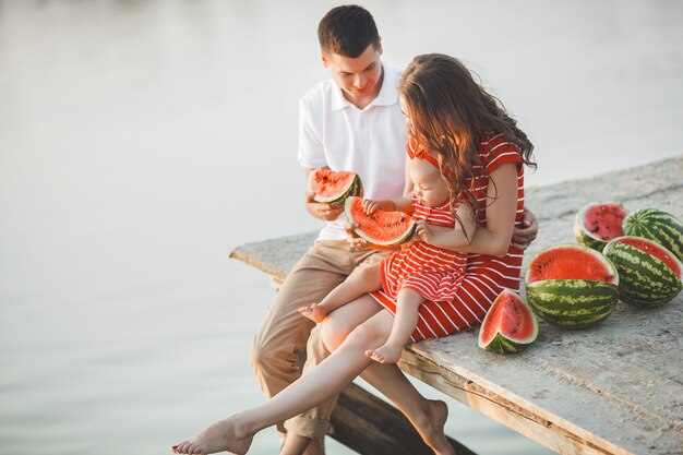 famiglia seduto vicino all'acqua sul ponte