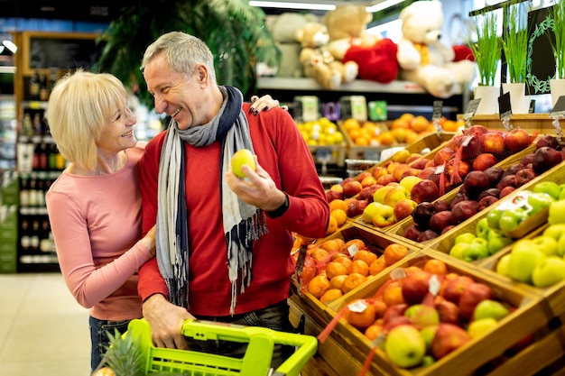 Famiglia senior felice che sceglie frutti ecologici al negozio