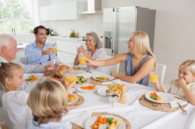 Famiglia sorridente che alza insieme i loro vetri