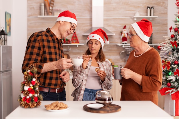 Famiglia sorridente che celebra insieme la stagione natalizia a Natale decorato culinaria