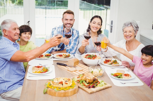 Famiglia sorridente che clinking con i bicchieri