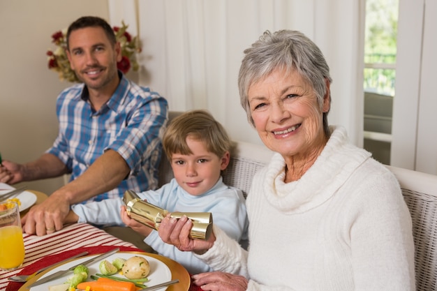 Famiglia sorridente che tira i cracker di natale a tavola