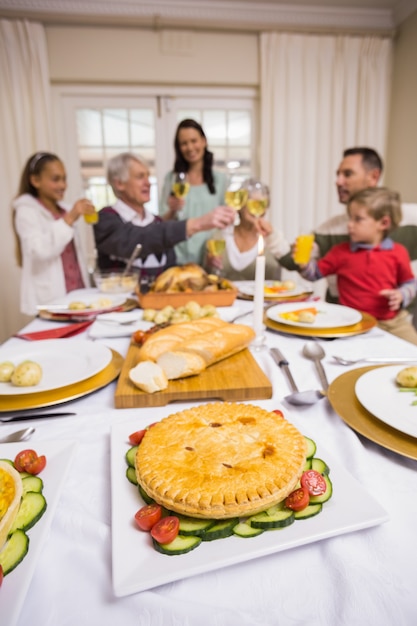 Famiglia sorridente che tosta alla cena di natale