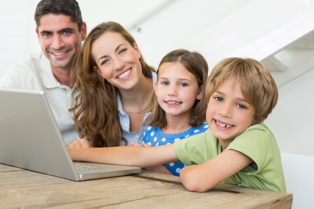 Famiglia sorridente con laptop