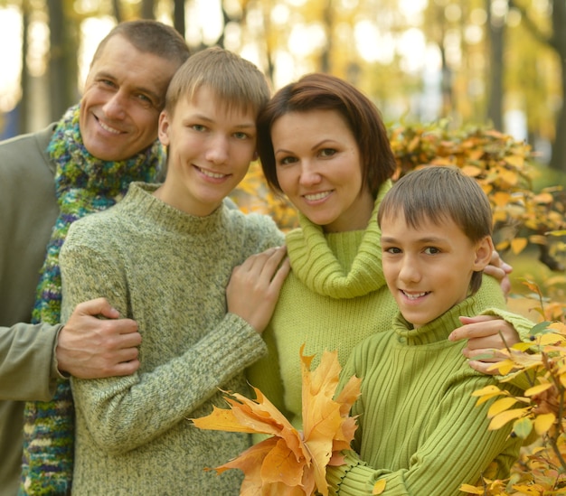 Famiglia sorridente felice che si rilassa nel parco d'autunno