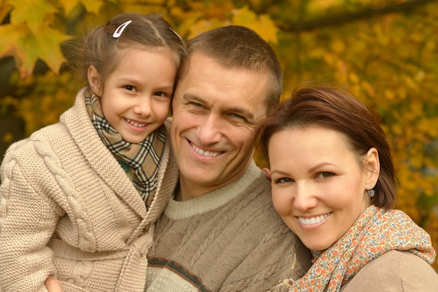 Famiglia sorridente felice che si rilassa nel parco d'autunno