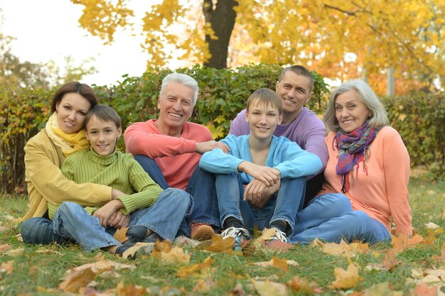 Famiglia sorridente felice che si rilassa nel parco d'autunno