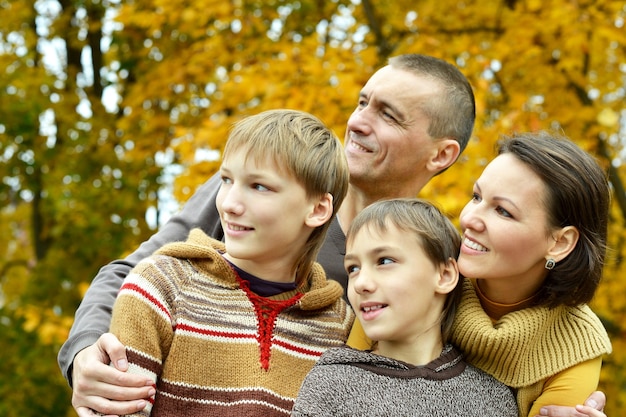 Famiglia sorridente felice che si rilassa nel parco d'autunno