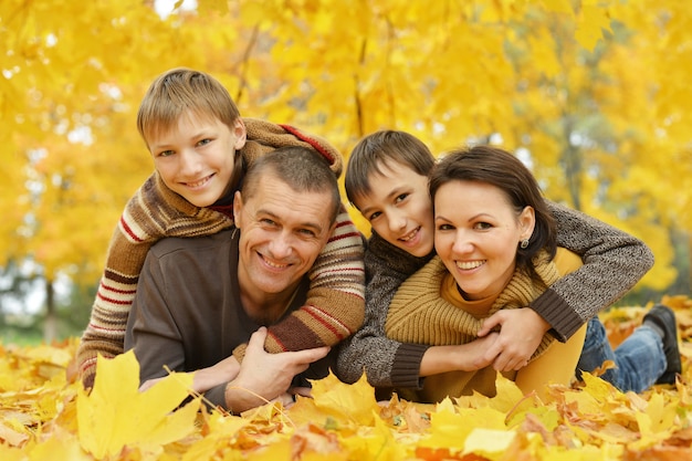 Famiglia sorridente felice che si rilassa nel parco d'autunno