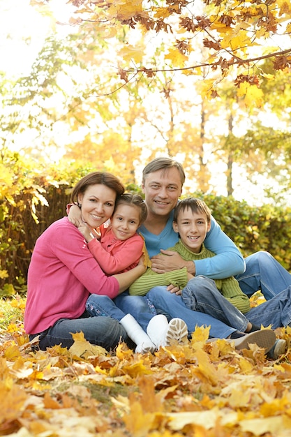 Famiglia sorridente felice che si rilassa nel parco d'autunno
