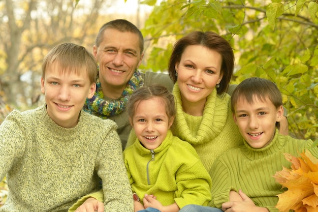 Famiglia sorridente felice che si rilassa nel parco d'autunno