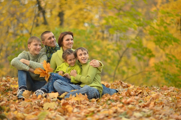 Famiglia sorridente felice che si rilassa nel parco d'autunno