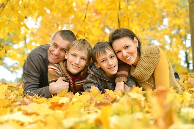 Famiglia sorridente felice che si rilassa nel parco d'autunno