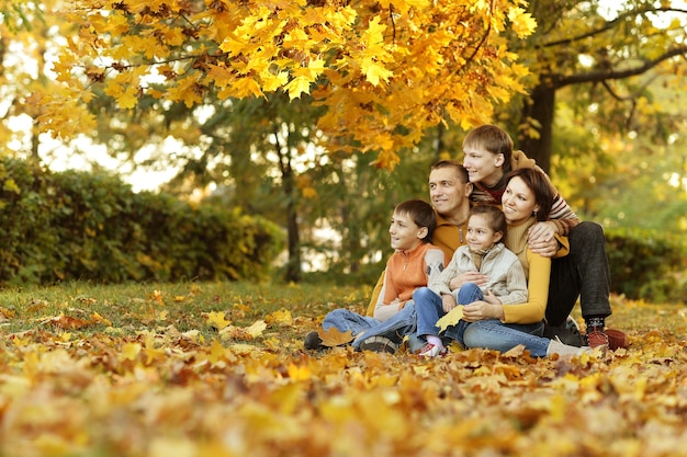 Famiglia sorridente felice che si rilassa nella foresta di autunno