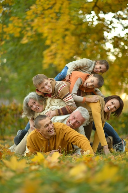 Famiglia sorridente felice che si rilassa nella foresta di autunno