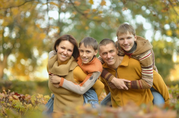 Famiglia sorridente felice che si rilassa nella foresta di autunno