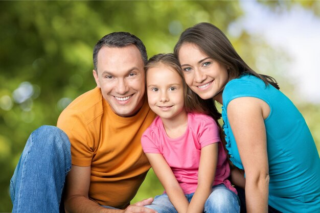 Famiglia sorridente felice con la figlia sullo sfondo del parco