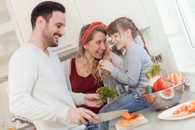 Famiglia sorridente felice in cucina a preparare la colazione