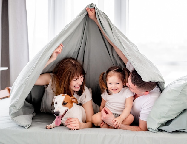 Famiglia sotto le coperte nel letto