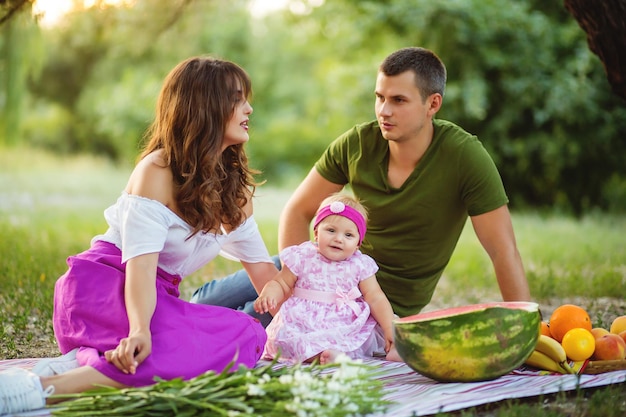 Famiglia su un picnic all'aperto con una piccola figlia carina