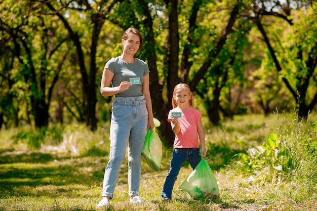 Famiglia sveglia che raccoglie immondizia nel parco