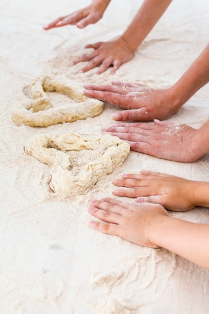 Famiglia, una giovane madre con la figlia e il figlio hanno fatto un cuore con la pasta in cucina.