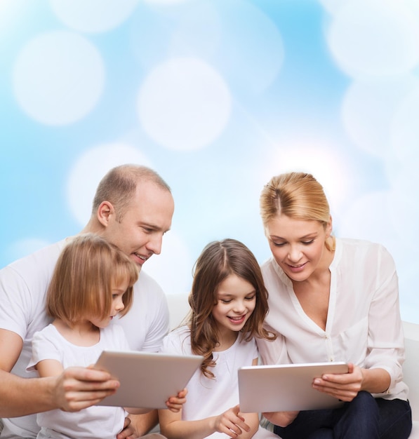 famiglia, vacanze, tecnologia e persone - madre, padre e bambine sorridenti con computer tablet pc su sfondo di luci blu
