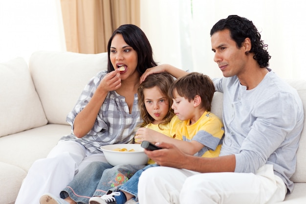 Famiglia vivace che guarda TV sul sofà