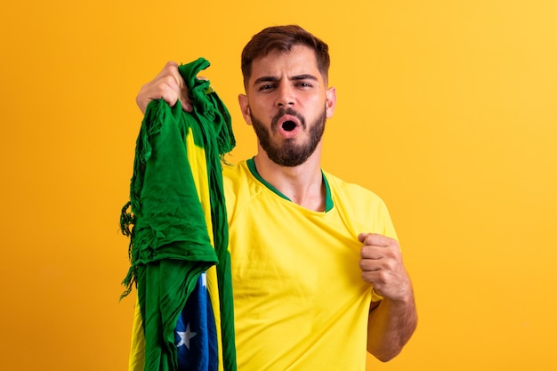 Fan brasiliano che acclamava tra la folla su sfondo giallo.