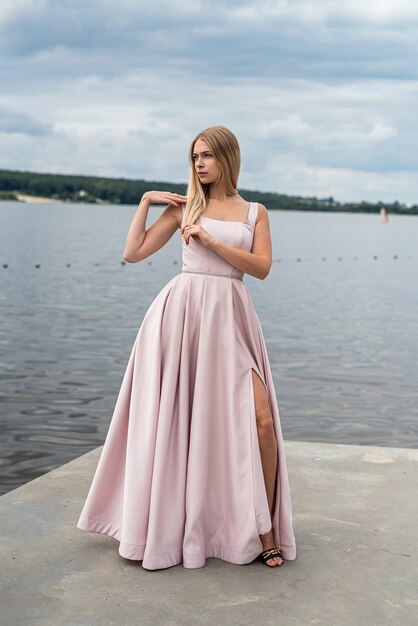 Fantasia affascinante donna in elegante abito da sera ping rilassante vicino al lago, ora legale