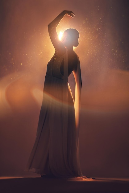 Fantasia arancione illuminazione e silhouette di donna sul palco per la moda creativa art deco e bellezza Ballerina estetica e ombra della ragazza posano per la magia dei sogni e la libertà in uno studio luminoso