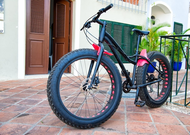 Fantastica bicicletta sportiva con scafo in ferro e plastica e grandi ruote in gomma di colore nero in piedi su strada sassosa all'aperto con nessuno